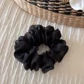 Close-up detail of a black mesh scrunchie, elegant hair tie with high elasticity for women. - Black