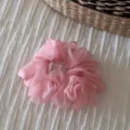 Detailed close-up of a pink organza hair scrunchie showing the fluffy translucent fabric texture. - Pink