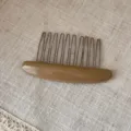 Detailed view of elegant oval acetate hair comb with metal teeth, versatile chic hair accessory. - Apricot