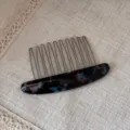 Detailed view of exquisite oval acetate hair insert comb with metal teeth for elegant styling. - Black Blue