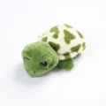 Cute plush turtle toy detail view with green and cream patterned shell and big glossy eyes. - Turtle Brooch Hair Clip