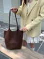 Detail view of a dark brown leather woven tote bag, large capacity daily commuting shoulder bag. - Coffee