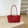 Detailed view of the red woven hollow-out shoulder bag, showcasing intricate craftsmanship. - Red