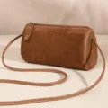 Brown suede barrel bag detail showcasing soft texture, premium zipper, and strap. - Brown