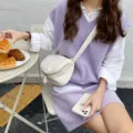 Detail shot of a trendy white soft leather crossbody bag with a wide strap, lifestyle aesthetic. - White
