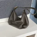 Soft slouchy shoulder bag detail showing premium leather texture and curved hobo shape design. - Gray
