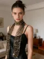 Detailed close-up of a trendy black mesh sequin scarf sparkling fashionable neck accessory. - Black and Gold