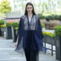 Détail de scène en extérieur montrant le châle kimono en dentelle bleue avec motifs floraux. - Bleu marine