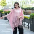 Détail du châle kimono en dentelle rose avec motif floral creux et ourlet à franges. - Rose