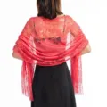 Detail view of a coral red lace evening wrap shawl with fringe for women at parties. - Watermelon red