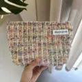 Nahaufnahme der bunten Tweed Kosmetiktasche, zeigt feine Textur und ein genähtes Etikett. - Weißgold Klassischer Tweed-Stil