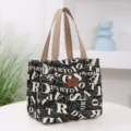 Thickened canvas lunch bag with stylish letter print, durable handles, and front pocket for work. - Letter Print Style / Black