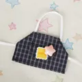 Primo piano dettagliato di un grembiule a quadri per bambola 10cm con tasca e bottone. - Sciarpa Stella Rosa