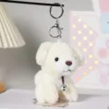 Primo piano dettagliato del portachiavi in peluche di cucciolo bianco con campanello metallico. - Portachiavi in Argento / Bianco / 12cm