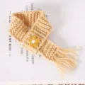 Detail van de gebreide mini poppensjaal, geel met een schattig bloemenmotief erop. - Khaki