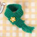 Mini groene gebreide poppensjaal met gele bloemborduursel, perfect als schattig accessoire. - Groen