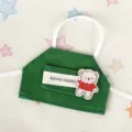 Vista dettagliata del grembiule in denim verde da 10 cm con tasca e patch di orsetto. - Grembiule Orso Verde