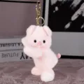 Close-up view of a cute pink plush pig keychain with soft fabric and golden metal clasp details. - Pink Pig (Gold Keychain)