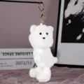 Close-up view of a fluffy white puppy plush keychain pendant, soft and cute accessory. - White Dog (Gold Keychain)
