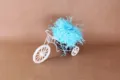 Gedetailleerd aanzicht van blauw opvulsel voor geschenkdozen in een witte miniatuurfiets. - Blauw