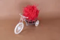 Gedetailleerd overzicht van witte decoratieve driewieler met rood opvulmateriaal voor dozen. - Rood