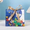 Children's Day paper gift bag with cute cartoon airplane design and gold ribbon bow. - Cartoon 0126 (Gold Ribbon) - Small