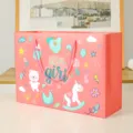 Pink paper gift bag for baby shower, cute cartoon design with carry handles, perfect for party gifts. - 096 Pink Ribbon - Small