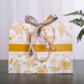 Bloemige cadeautas van papier met strik, elegante verpakking voor kleding en cadeaus. - Kleine Maat 18x16x10cm / Goud Bloemen zonder Tekst (Tweekleurig Lint)