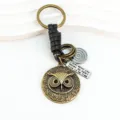 Vintage bronze owl keychain with black leather wrap and engraved quote tag for keys. - Black