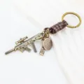 Detailed view of the creative metal rifle keychain with leather strap and tactical gun pendant. - Brown Leather Style