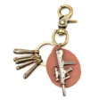 Close-up detail of vintage bronze alloy rifle keychain with brown leather piece and clips. - Leather Block Style