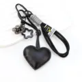 Llavero de corazón de cuero negro con correa trenzada mosquetón y dijes de flores para bolsos. - Negro