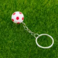 Vue detaillee du porte-cles mini ballon de football avec un design realiste en metal. - 2cm / Rouge