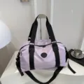 Lightweight purple travel duffel bag detail, featuring durable black straps and spacious interior storage. - Purple