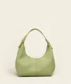 Detailed view of light green pebbled leather hobo bag with soft texture and short handle. - Green