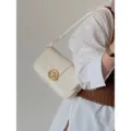 Gros plan sur un élégant sac à bandoulière blanc cassé avec fermoir doré rétro. - Blanc Cassé