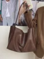 Close-up of the dark brown soft leather tote bag detail, showing soft texture and large capacity. - Coffee