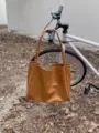 Detailed view of the vintage large capacity soft PU leather brown tote bag for women. - Brown