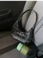 Vue détaillée du sac noir en cuir avec boucle étoile en métal et bandoulière élégante. - Noir