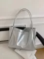 Silver metallic tote bag detail, soft shoulder strap lifestyle shot, minimalist aesthetic. - Silver