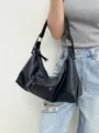 Vista dettagliata di una borsa a tracolla moto vintage nera indossata sulla modella. - Nero