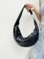 Borsa a spalla a mezzaluna in pelle nera, design croissant minimalista e trendy. - Nero
