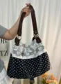 Vue de détail de la poignée et du tissu de ce sac fourre-tout à pois en dentelle coréenne. - Noir
