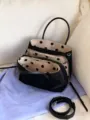 Vista dettagliata dell'interno della borsa in nylon nero con fodera a pois e cerniere. - senza ciondolo / pois neri