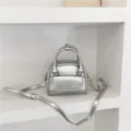 Silver mini handbag detail showing metallic finish, dual handles, and front pocket design. - Standard / Silver