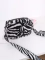 Close-up detail view of a stylish black and white zebra pattern crossbody bag with a wide strap. - Zebra Print