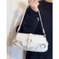 Borsa a tracolla in pelle bianca stile moto con eleganti fibbie in metallo per donne. - Bianco