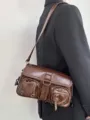 Borsa a tracolla in pelle lucida marrone da donna, stile moto alla moda con tasche. - Marrone
