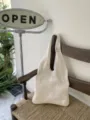 Vista dettagliata di una borsa tote intrecciata all'uncinetto color crema, stile casual. - Albicocca