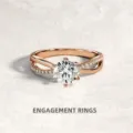 Primo piano dell'anello di fidanzamento in oro rosa con diamante centrale e fascia incrociata. - Oro rosa
